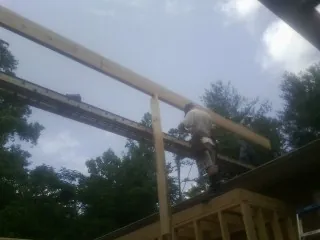 Carpenter setting a ridge beam over a new addition frame — Ice Dam Removal by Roofing Brothers in Penn
