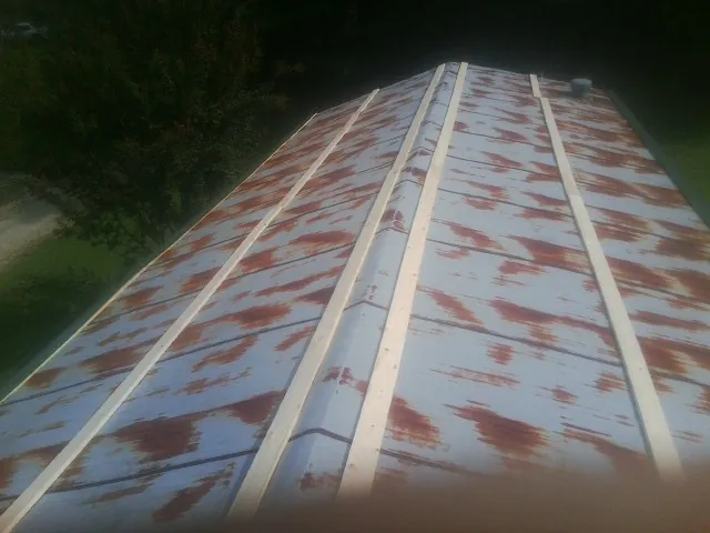 Rusted metal roof panels with new wood purlins before replacement — Storm Damage Roof Repair in Penn by Roofing Brothers