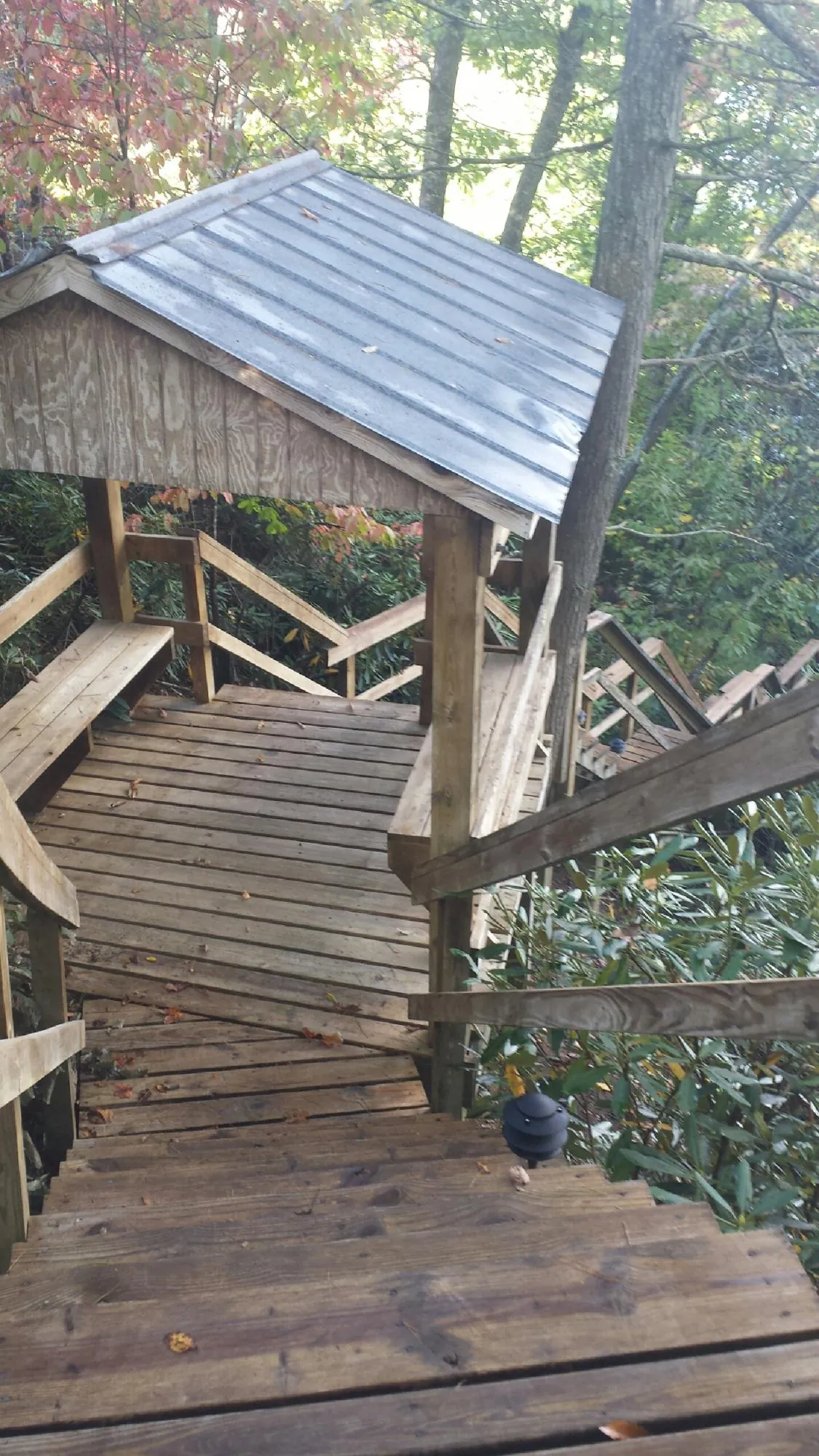 Metal roofed shelter over wooden steps on a wooded walkway — Skylight Repair & Installation work by our crew in Penn