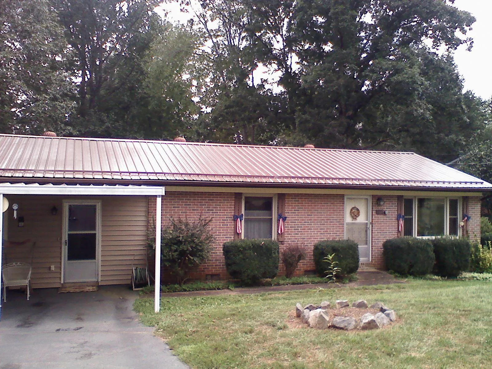 Bronze metal roof and carport on a brick ranch home — Roof Repair work by our crew in Penn