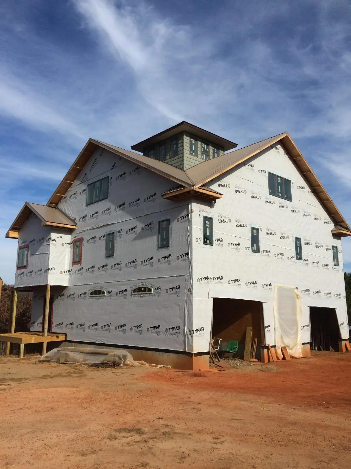 New two story house under construction with a cupola and gabled roofs in Penn